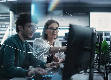 Two coworkers discussing in an office building.