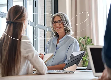 Two women discussing in an office building.