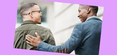Two coworkers of different races smilling together.