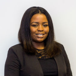 Person smiling in a professional outfit.