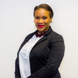 Person smiling in a professional outfit against a white background.