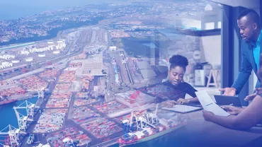 Aerial view of a port with people in an office discussing documents.