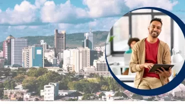 Smiling person holding a tablet with a cityscape in the background.