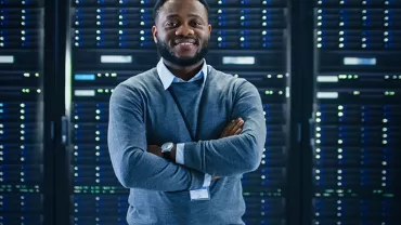 Person standing confidently in a server room.