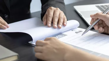 Two people reviewing a resume at a desk.
