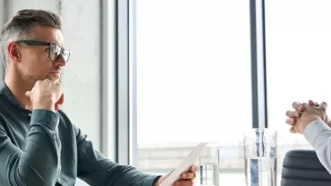 Two people having a serious discussion in an office setting.