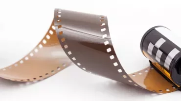 A roll of unwound photographic film on a white background.