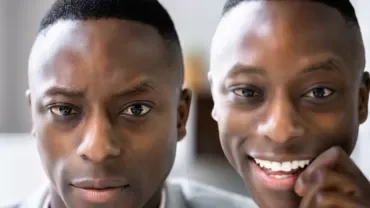 Close-up of one serious and one smiling person.