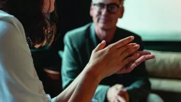 Two individuals having a serious conversation in a cozy setting.