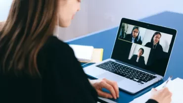 Person participating in a video conference on a laptop.