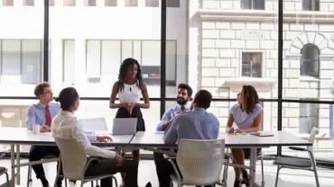 People in a meeting room with large windows.
