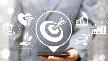 Person holding phone with icons of industry, healthcare, finance, and environment surrounding a target symbol.