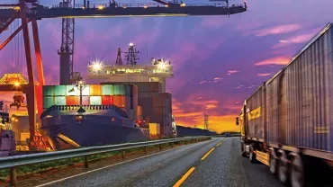 Cargo ship and truck at a port during sunset