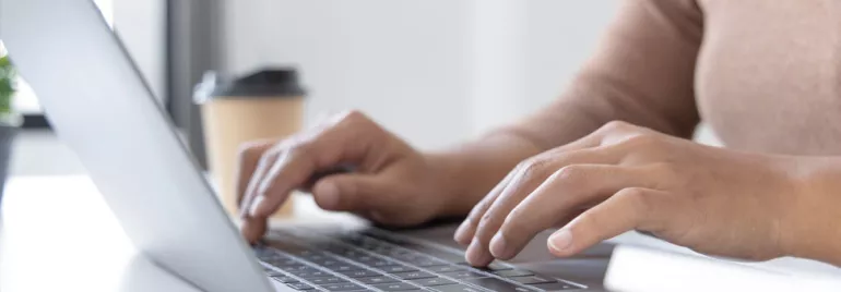 Personne tapant sur un ordinateur portable à un bureau.