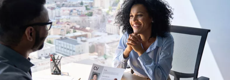 Personne souriante lors d'un entretien dans un bureau avec vue sur la ville.