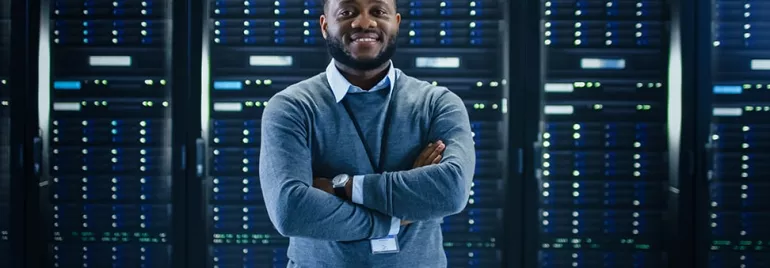 Person standing confidently in a server room.