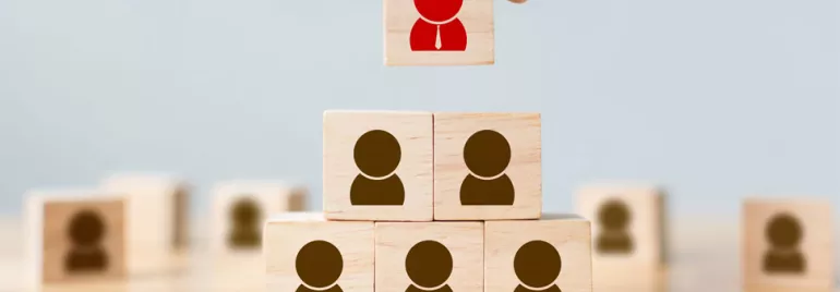 Cubes en bois en pyramide, le cube supérieur avec un symbole rouge.