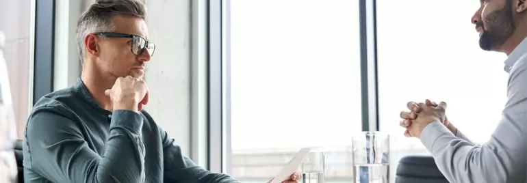 Two people having a serious discussion in an office setting.