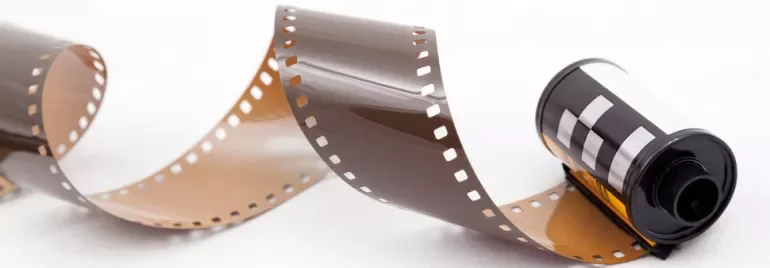 A roll of unwound photographic film on a white background.