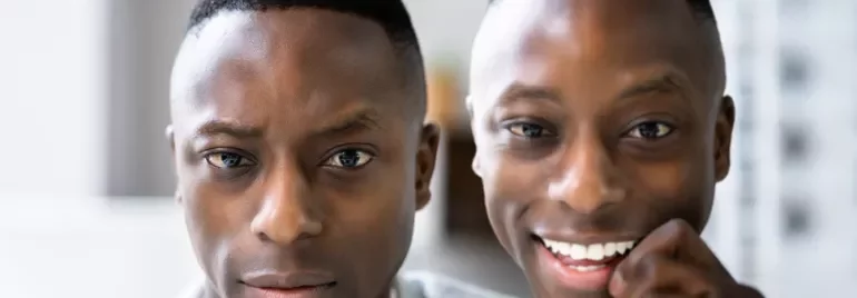 Close-up of one serious and one smiling person.