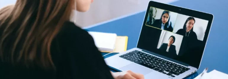Person participating in a video conference on a laptop.