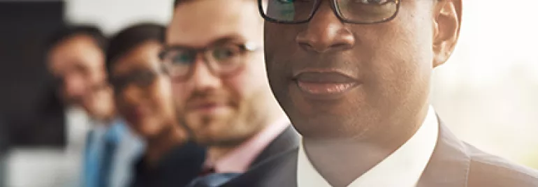 Groupe de professionnels en costume, une personne au premier plan.