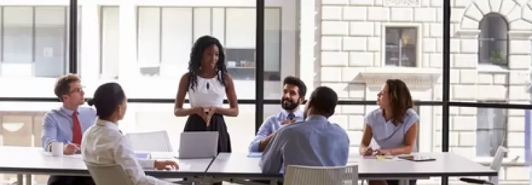 Réunion de personnes dans une salle avec de grandes fenêtres.