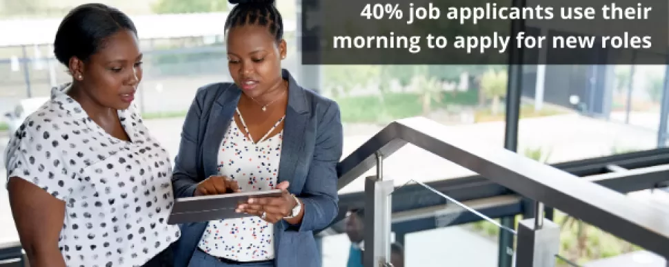 Two people reviewing a tablet, statistic about job applications shown.