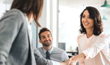 Business meeting with a friendly handshake in an office.