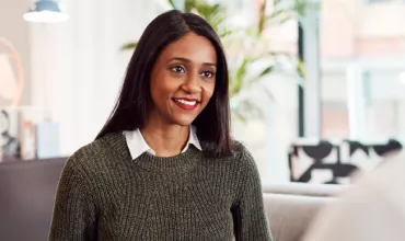 Person smiling in a modern office setting.