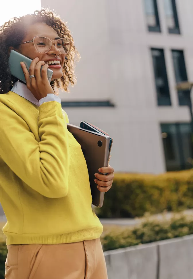 A woman in a yellow office attire making a call.