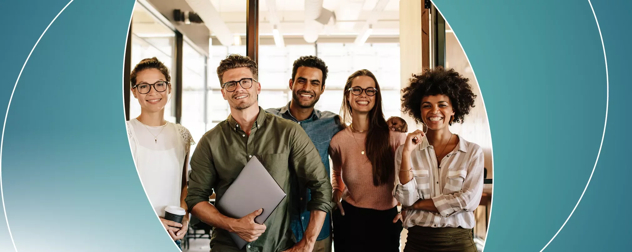 A group of people standing together, smiling in an office setting.