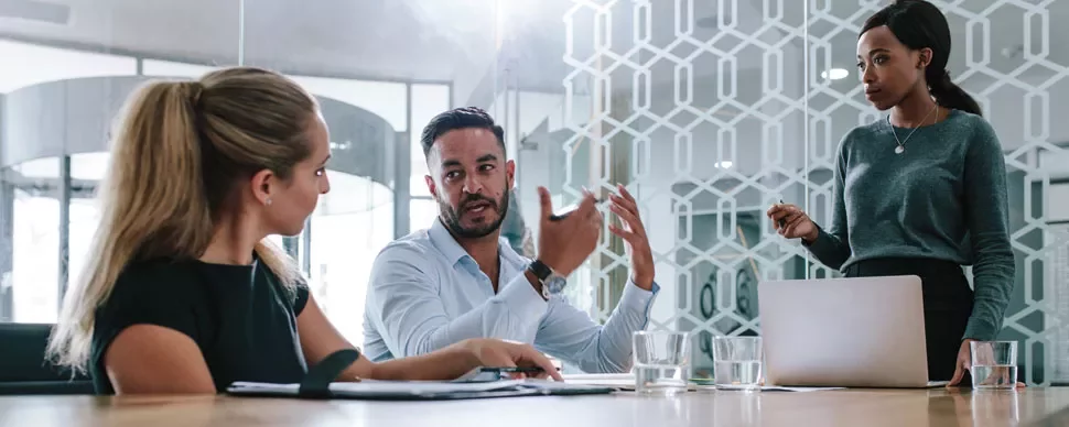 Three people having a meeting in a modern office.