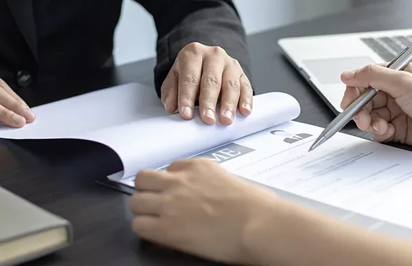 Two people reviewing a resume at a desk.