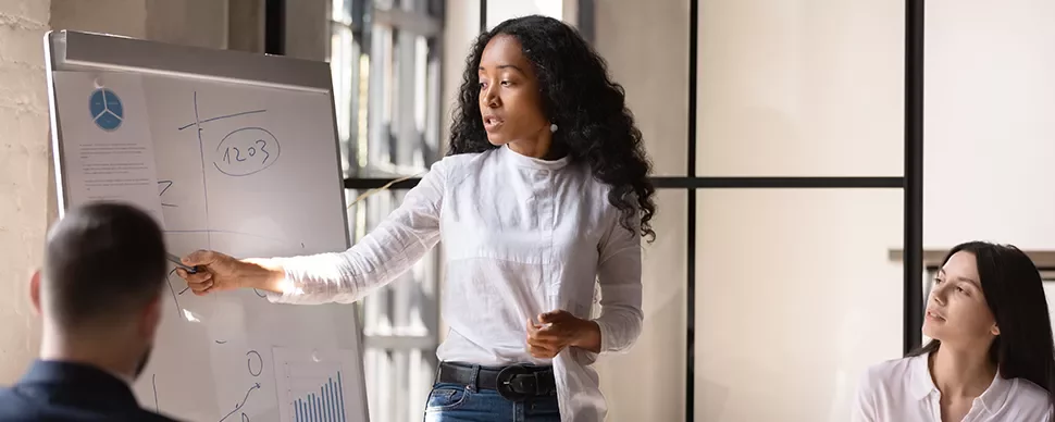 Person giving a presentation with a whiteboard in an office.