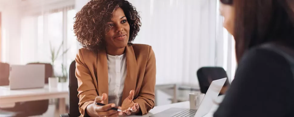 Two people having a conversation in an office setting.