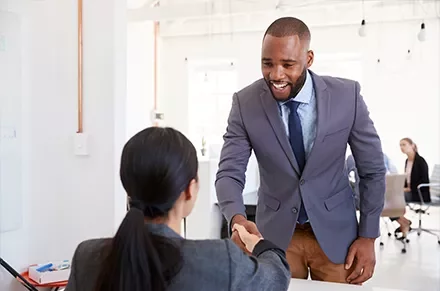 Professional handshake in an office setting.