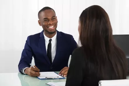 Person smiling during an office meeting.
