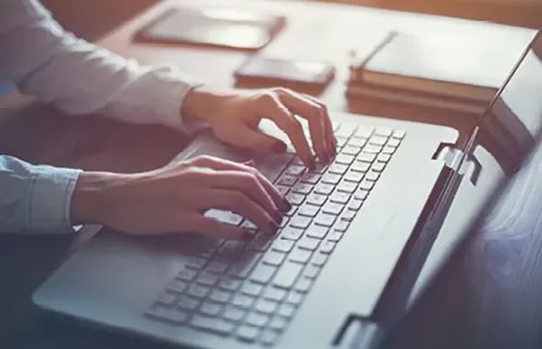 Person typing on a laptop at a desk.